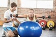 © WavebreakmediaMicro - Male trainer helping young woman with the dumbbells