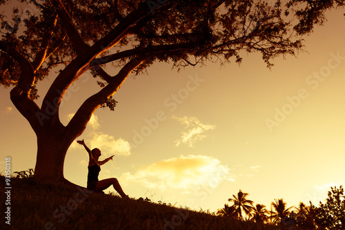 Fotografie, Tablou Silhouette of woman with hands raised into the sunset