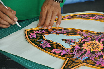 Malaysian kite maker working on a kite in his workshop