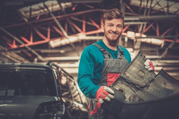 Sticker - Mechanic with car bumper in a workshop