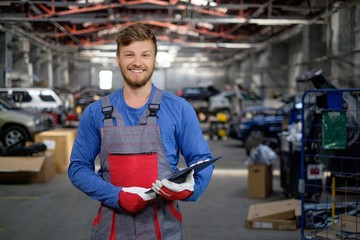 Cheerful serviceman in a car workshop