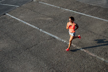Top View Of Woman Running On City Asphalt. Female Runner Training Outdoor.