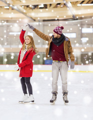 Wall Mural - happy couple holding hands on skating rink