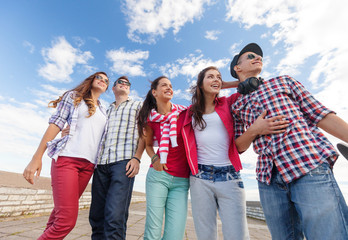 Wall Mural - smiling teenagers in sunglasses hanging outside