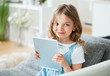 © Westend61 - Little girl holding digital tablet