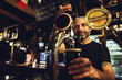 © Westend61 - Man tapping beer in an Irish pub
