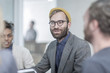 © Westend61 - Man with glasses and yellow beanie in meeting with colleagues