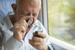 © Westend61 - Senior man reading text on a cell phone with a magnifying glass