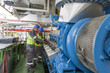© Westend61 - Crew working in engine room on a ship