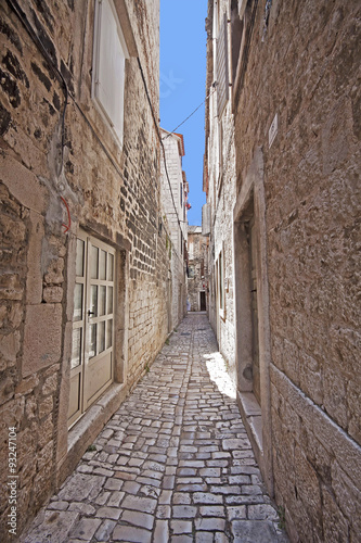 Plakat na zamówienie Trogir, Croatia - Narrow cobbled street in Trogir center, antique Dalmatian city founded 4000 years ago.