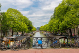 Fototapeta Zachód słońca - Bicycles on a bridge over the canals of Amsterdam