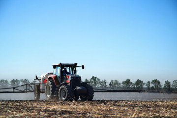 Poster - The tractor works in a field