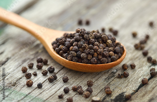 Cuadros en Lienzo Whole black pepper on wooden spoon