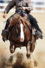 A Front View Of A Rider And Horse Running Ahead In The Dust.