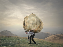 Businessman Carrying A Big Rock