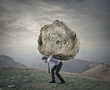 © olly - Man carrying a heavy rock