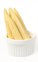 Fresh baby corns in white plate on 
white background