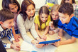 © Syda Productions - group of kids with teacher and tablet pc at school