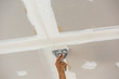 © bouybin - man hand with trowel plastering a ceiling, skim coating plaster