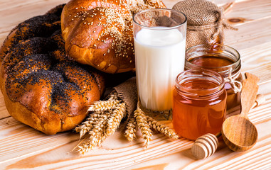 tasty buns with poppy and sesame milk and honey on wooden backgr