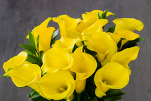 Bouquet Of Yellow Calla Lilies (Zantedeschia) Over Dark Wooden Background