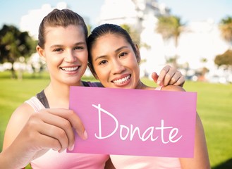 Wall Mural - Donate against two smiling women wearing pink for breast cancer