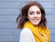 © NinaMalyna - Beautiful natural young smiling brunette woman wearing knitted sweater gloves and scarf. Fall and winter fashion concept.