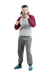 Wall Mural - Young sporty casual man in sportswear with boxing hand gesture isolated