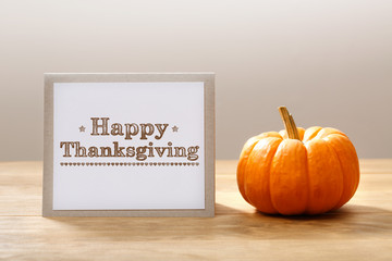 Wall Mural - happy thanksgiving message with a small pumpkin