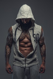 Fototapeta Tęcza - Gangsta tattooed muscular man in a hood.