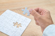 © Bits and Splits - Businessman hand putting a missing piece into jigsaw puzzle