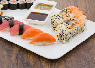 Sushi set on a white plate over vintage wooden background