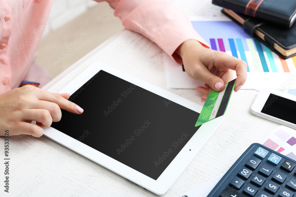 Concept for Internet shopping: hands with digital tablet and credit card