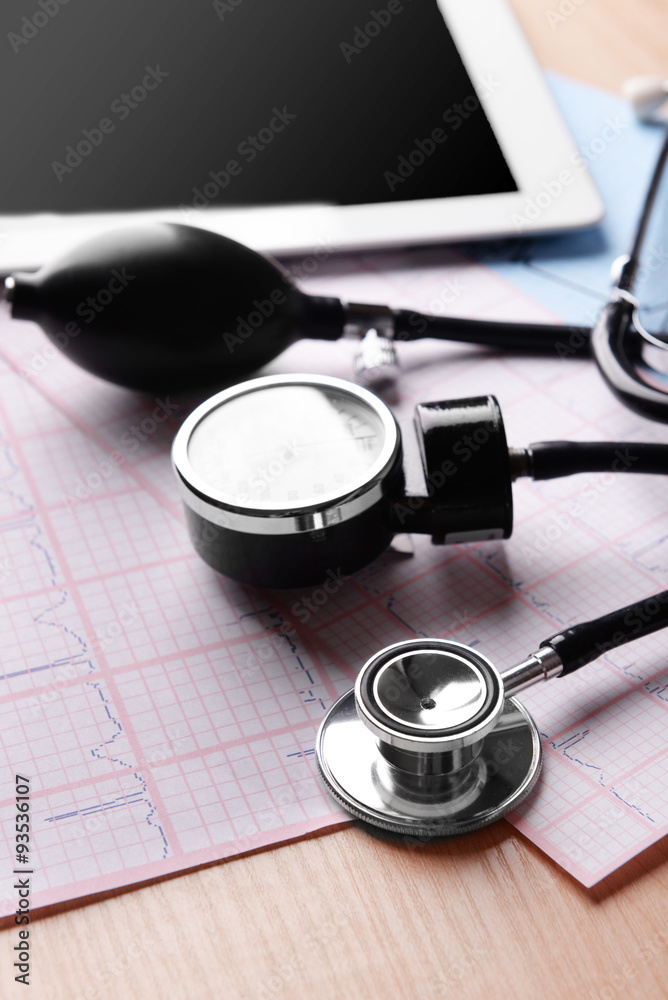 Blood pressure meter, digital tablet and stethoscope, on wooden background