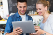 © pikselstock - Young cafe owners looking at laptop