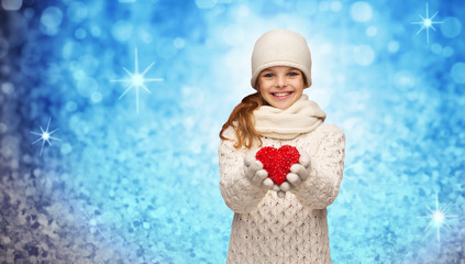 Canvas Print - girl in winter clothes with small red heart