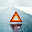Winter driving  - Warning triangle on a winter road
