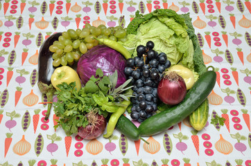 Violet and green healthy vegetables and fruits on tablecloth wit