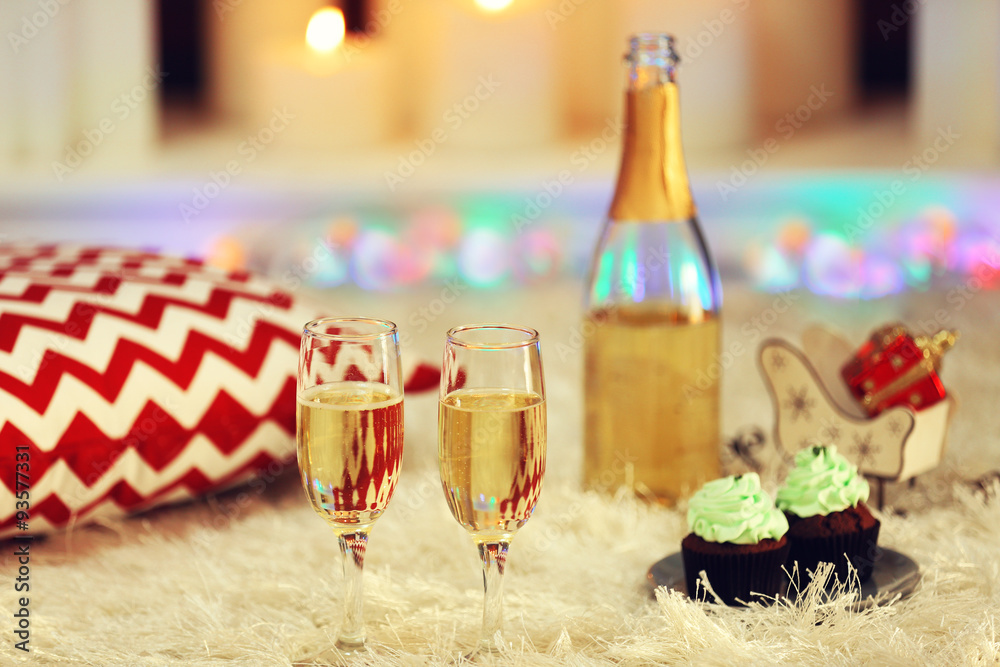 Delicious cupcakes and champagne on home interior background