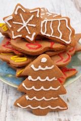 Fresh baked decorated gingerbread on old wooden background, christmas time