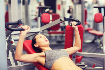 Wall Mural - young woman exercising on gym machine