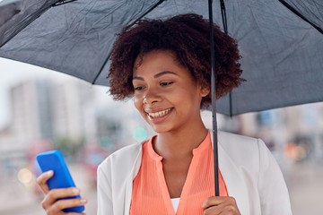 Poster - businesswoman with umbrella texting on smartphone