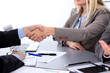 © rogerphoto - Business people shaking hands, finishing up a meeting