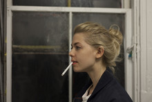 Side View Of Young Woman Smoking Cigarette