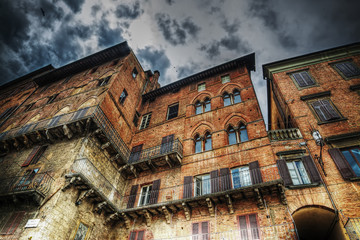 Wall Mural - old building in Siena under a dramatic sky