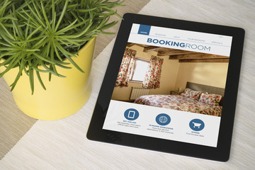 Wall Mural - Tablet booking over a table with plant