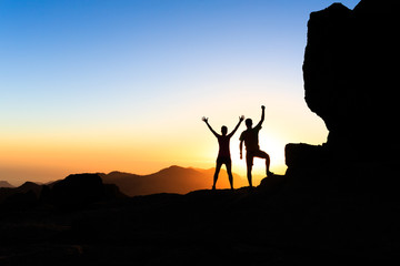 Wall Mural - couple hikers success concept in mountains