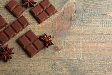 Wall Mural - tender milk chocolate and star anise on wooden background