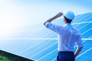 solar power plant. man standing near solar panels. renewable energy.