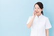 © taka - portrait of asian nurse on blue background